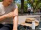 Persona aplica protector solar en el brazo antes de realizar actividades al aire libre.
