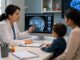 Médica conversa con una madre durante evaluación neurológica de un niño pequeño por posibles señales de enfermedad de Batten infantil.