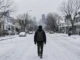 Hombre migrante camina solo por una ciudad cubierta de nieve, imagen inspirada en Demasiado al norte de Emiliano Pérez Grovas.
