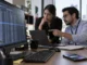 Especialistas analizan una posible exposición de datos personales en una computadora, con un teléfono sobre el escritorio