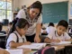 Estudiantes de primaria trabajan con su maestra en un salón de una escuela pública mexicana.