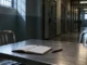 Sala de entrevista penitenciaria vacía con mesa, sillas y libreta, imagen alusiva a Crímenes atroces de Enrique Zúñiga.