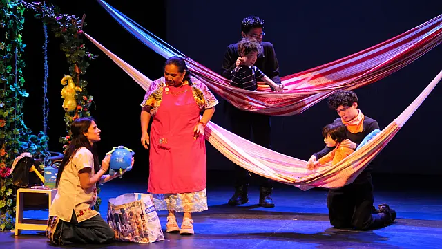 Escena de la obra Pedro y Julián, dirigida por Conchi León, con actores, títeres y hamacas sobre el escenario teatral.