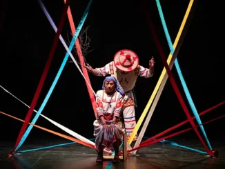 Escena teatral inspirada en Nacahue: Ramón y Hortensia, con dos personajes separados por un río simbólico en una adaptación indígena de Romeo y Julieta.