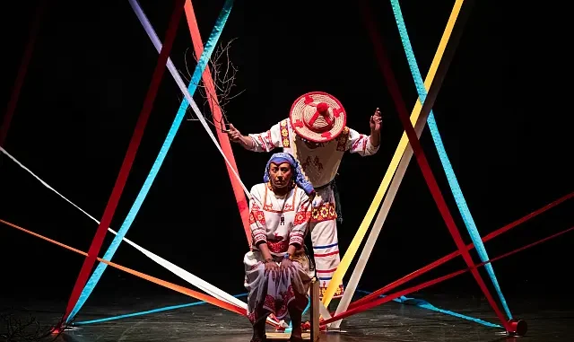 Escena teatral inspirada en Nacahue: Ramón y Hortensia, con dos personajes separados por un río simbólico en una adaptación indígena de Romeo y Julieta.