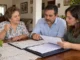 Padre revisa con sus hijos documentos y opciones para dejar una casa como herencia en México.
